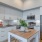 Downtown Oakland, CA Apartments - Caspian - Kitchen with White Cabinetry, Stainless Steel Appliances, White Tile Backsplash, and a Kitchen Island